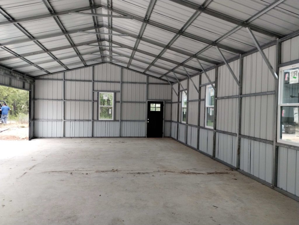 Interior view of a metal building under construction with exposed framing and windows